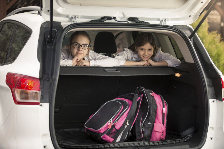 Mochilas de niñas en el maletero del coche