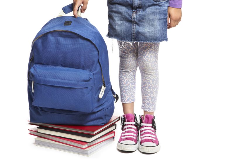 Niña con una mochila azul con libros